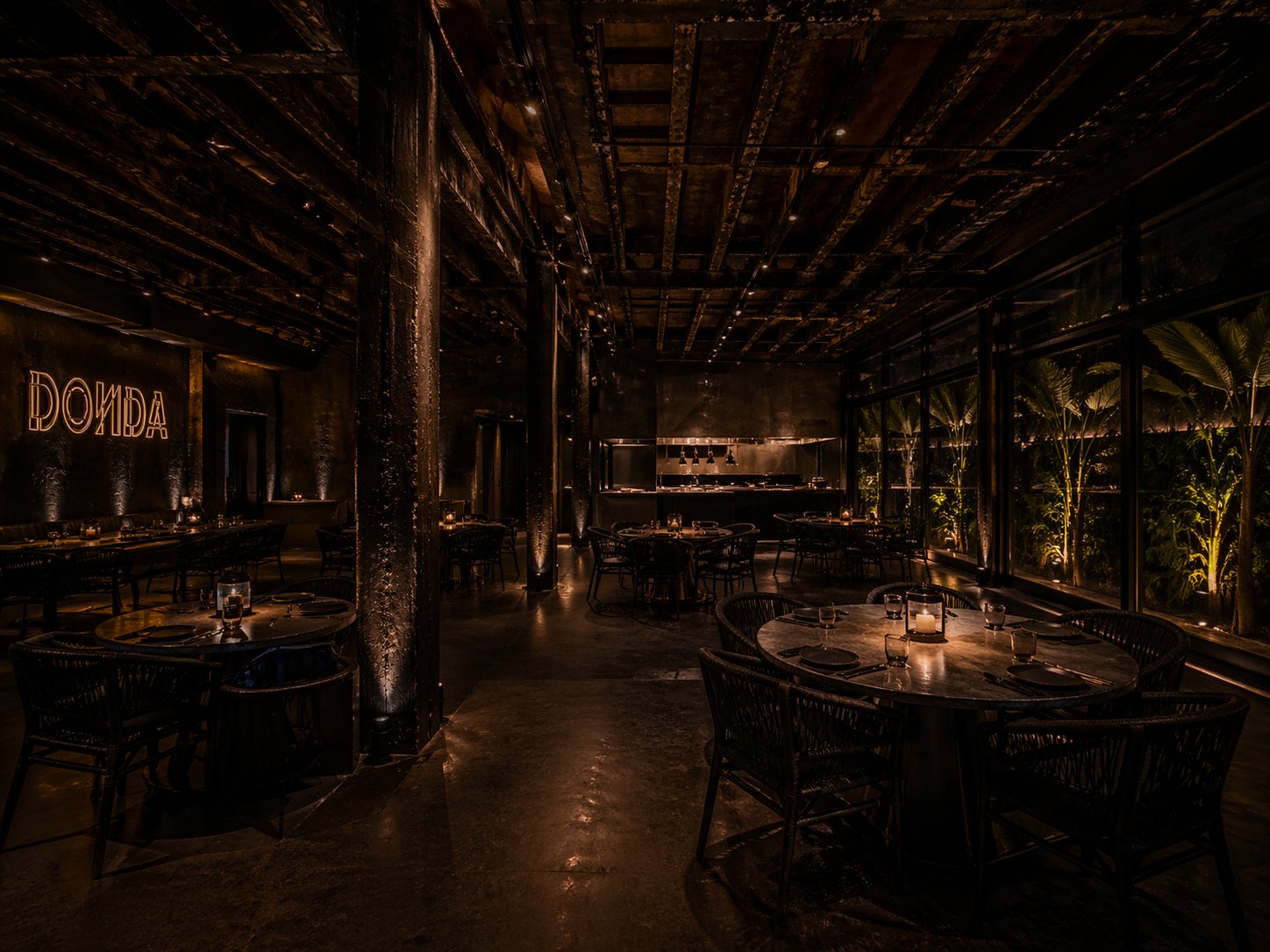 The DONDA dining room, candlelit, with the open kitchen visible at the heart of the room
